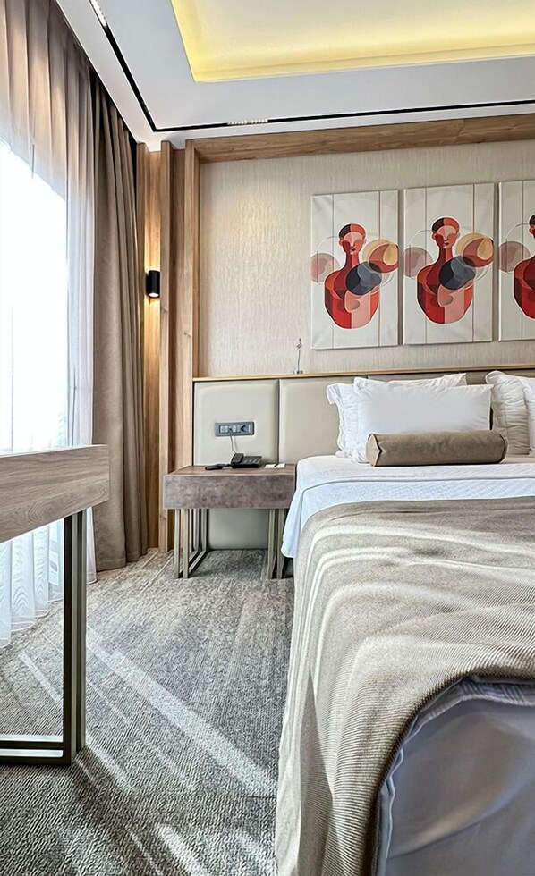 A hotel room with a bed, bedside table, lamp, artwork, and a view of the outdoors. - SOLIA HOTEL (Mezitli)