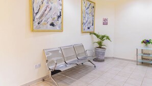 A reception area with a bench, two abstract paintings, a potted plant, and a no smoking sign. - Spring Resort  (Hurungwe)