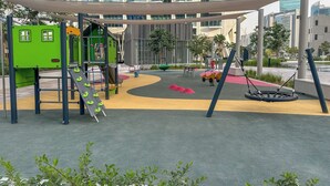 Ein Spielplatz mit Rutsche, Schaukeln und Klettergerüsten.