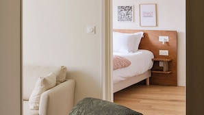 A room with a bed, a sofa, and a small table with a lamp. - Alfred Hotels Montreuil - Hôtel Rénové (Montreuil)