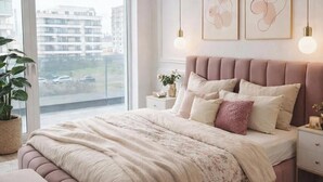 Een slaapkamer met een groot bed, nachtkastjes, een raam met uitzicht en kunst aan de muur.