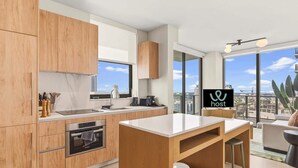 Una cocina moderna con armarios de madera, una isla central y un comedor con vista a la ciudad.