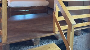 Ein Schlafzimmer im Landhausstil mit Bett, Holzschreibtisch und einer Steinwand.