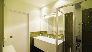 Un baño con lavamanos, espejo y ducha blancos.