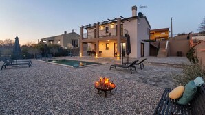 A modern house with a pool, outdoor seating, and a fire pit. - Villa Lumina Divina-Modern villa with Heated Pool (Prhati)