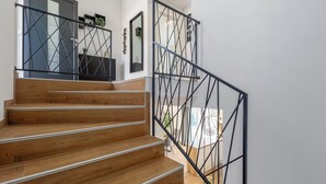 A staircase with wooden steps and black metal railings. - Villa Lumina Divina-Modern villa with Heated Pool (Prhati)