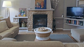 A living room with a fireplace, a television, and a bookshelf. - House in Palafolls Near Costa Brava Beaches (Palafolls)