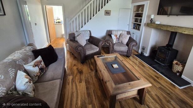A living room with a staircase, a fireplace, and a television. - Cosy, dog friendly, two-bedroom cottage in Hawes. (Hawes)