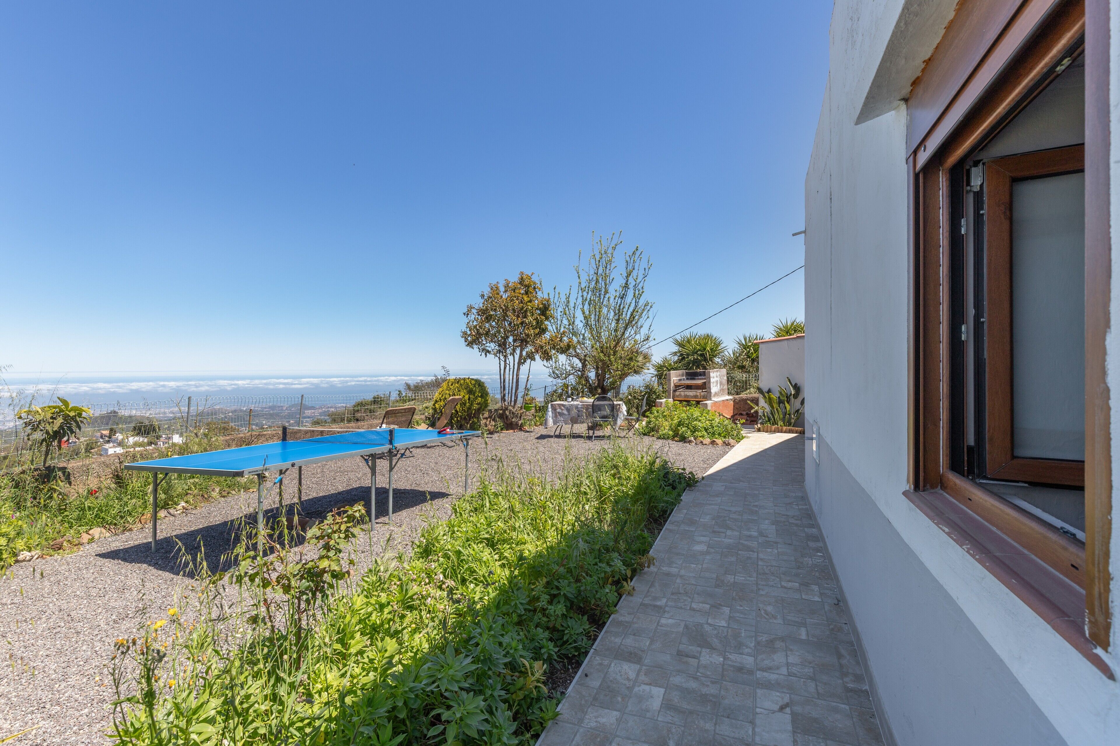 A pool, outdoor seating, and a view of the sea.