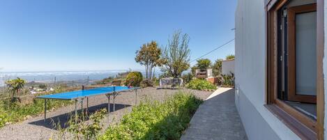 A pool, outdoor seating, and a view of the sea.
