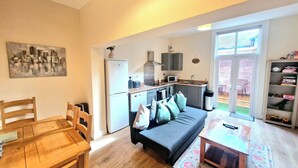 A compact living space with a kitchenette, a dining area, and a sofa. - City Stay Worcester - free parking (Worcester)