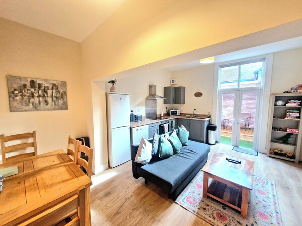 A compact living space with a kitchenette, a dining area, and a sofa.