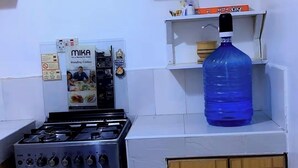 Een keuken met een gasfornuis, kastjes en een waterdispenser.