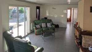 A spacious living room with a green sofa, a coffee table, and a fireplace.