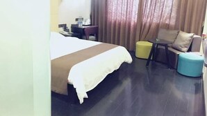 Una habitación de hotel con cama, escritorio, sillón y sofá.