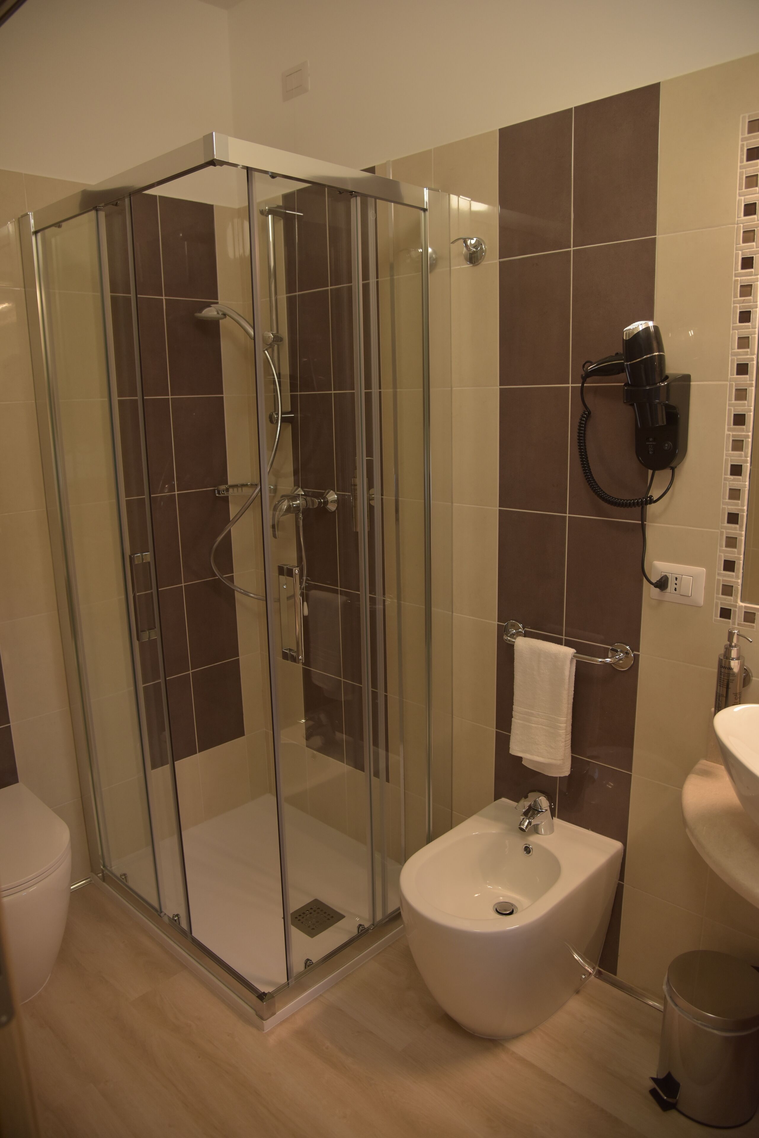 Une salle de bain moderne avec une douche à parois de verre, un bidet et un lavabo.