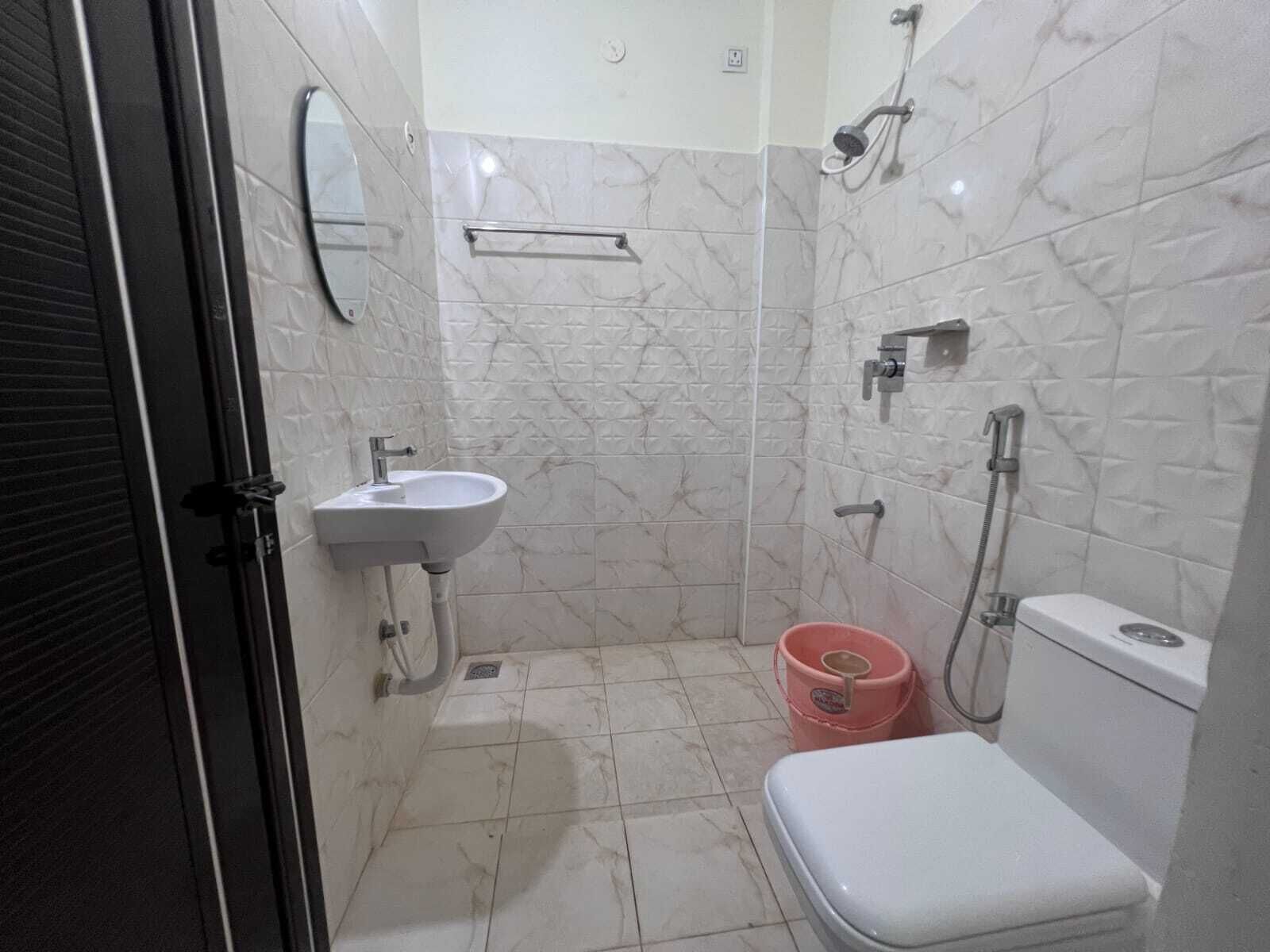 A small bathroom with a sink, toilet, and shower.