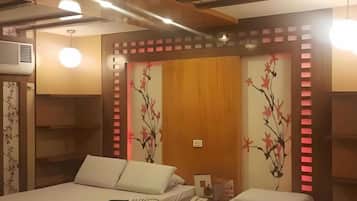 A hotel room with a bed, bedside tables, a phone, and decorative wall art.