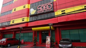 A multi-story hotel with a prominent red and yellow facade, a visible entrance, and a sign indicating 'HOTEL ENFRANCE.' - Hotel Sogo Pasay Harrison (Pasay)