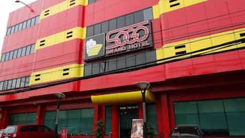 A multi-story hotel with a prominent red and yellow facade, a visible entrance, and a sign indicating 'HOTEL ENFRANCE.'