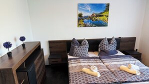 Un dormitorio con una cama de madera, ropa de cama estampada y un cuadro que muestra una escena junto al lago.