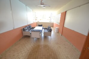 A room with a tiled floor, a ceiling fan, a sofa set, and a table. - Spacious flat with pool view (Bibione)