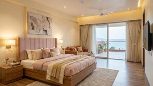 A spacious bedroom with a large bed, a seating area, and a balcony with a view. - Saapna Resort & Boat Club (Betūl)