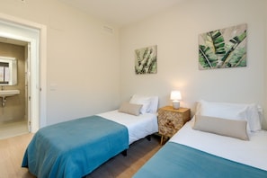 A hotel room with two beds, a bathroom, and artwork on the walls. - Bali Rincón | Stylish Apartment with Panoramic Sea & Mountain Views & Pool in Rincon de la Victoria (Rincón de la Victoria)