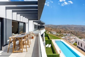 A modern outdoor terrace with a pool, seating area, and a view of the surrounding landscape. - Bali Rincón | Stylish Apartment with Panoramic Sea & Mountain Views & Pool in Rincon de la Victoria (Rincón de la Victoria)