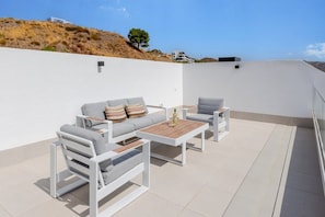 An outdoor patio with a sofa set, two side tables, and a wooden coffee table. - Bali Rincón | Stylish Apartment with Panoramic Sea & Mountain Views & Pool in Rincon de la Victoria (Rincón de la Victoria)