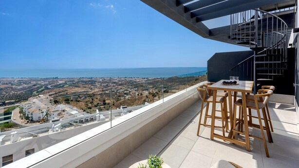 A balcony with a view of the sea, a table with chairs, and a spiral staircase. - Bali in Rincón | Elegant 2BR Apartment with Terrace & Ocean Views (Rincón de la Victoria)