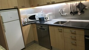 A modern kitchen with wooden cabinets, a microwave, a coffee maker, and a dishwasher. - Holiday Home 'Sunshine Home - 300m To The Beach' with Sea View, Private Terrace and Wi-Fi (Leça da Palmeira)