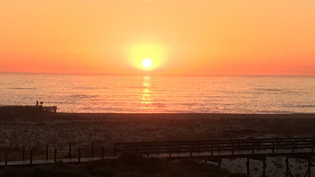 A sunset over a beach with a wooden pier and a fence. - Holiday Home 'Sunshine Home - 300m To The Beach' with Sea View, Private Terrace and Wi-Fi (Leça da Palmeira)