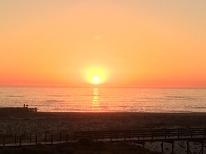 A sunset over a beach with a wooden pier and a fence. - Holiday Home 'Sunshine Home - 300m To The Beach' with Sea View, Private Terrace and Wi-Fi (Leça da Palmeira)