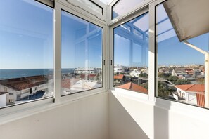 A corner of a room with large windows overlooking a coastal cityscape. - Holiday Home 'Sunshine Home - 300m To The Beach' with Sea View, Private Terrace and Wi-Fi (Leça da Palmeira)