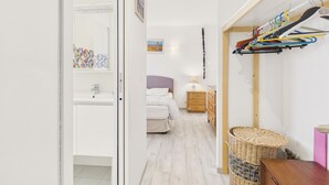 A bedroom with a bed, bedside table, lamp, and a wall-mounted coat rack. - House for 6 with garden, St Gildas town centre (Saint-Gildas-de-Rhuys)