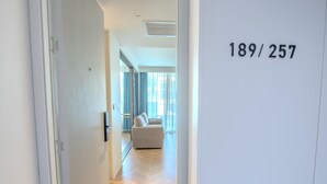 Une chambre d’hôtel moderne dotée d’une grande fenêtre, d’un canapé et d’une porte portant le numéro 189/257.