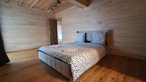 Une chambre à coucher avec un lit, des murs en bois et un luminaire au plafond.