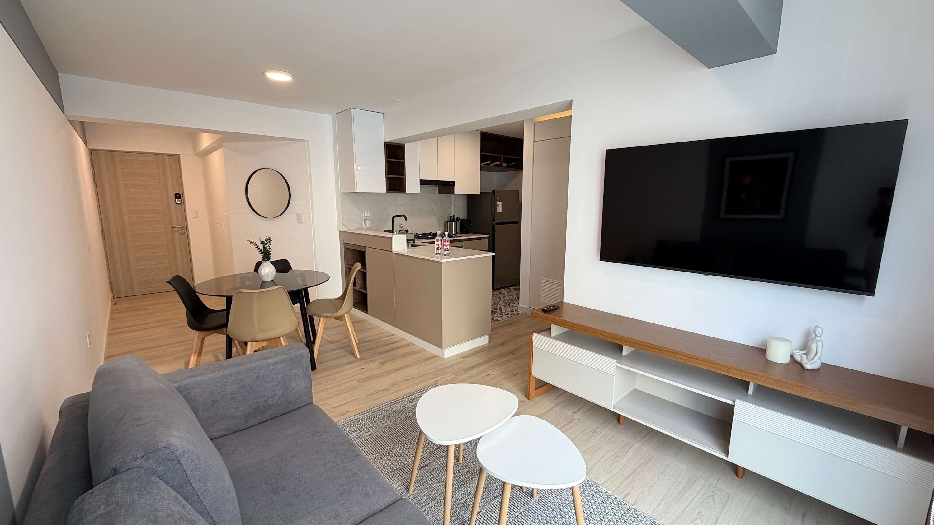 A modern living room with a grey sofa, a TV, and a small coffee table.