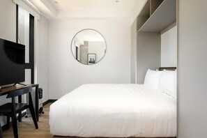 A modern hotel room with a large bed, a TV, and a round mirror on the wall. - w Inviting Loft in the Heart of Interlomas (Huixquilucan)