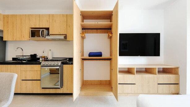 A modern kitchen with wooden cabinets, a built-in microwave, and a stove. - w Deluxe Loft w/ Balcony in Tabacalera (Mexico City)