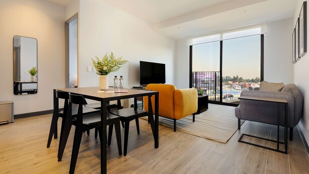 A modern living room with a dining table, chairs, a sofa, a TV, and a balcony with a view. - w Charming 2BR in the Heart of Interlomas (Huixquilucan)