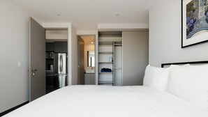 A modern hotel room with a large bed, a wardrobe, and a kitchenette. - w Charming 2BR in the Heart of Interlomas (Huixquilucan)