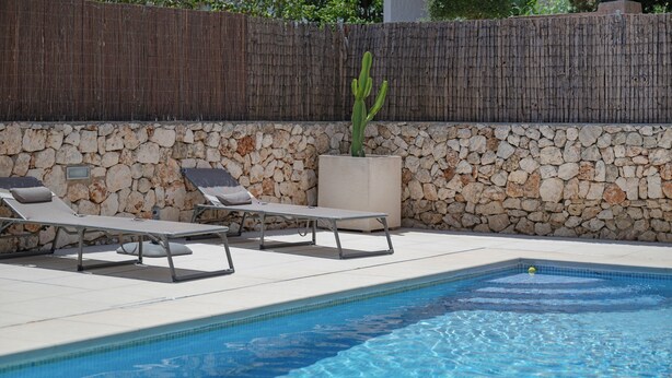 A swimming pool with lounge chairs and a cactus plant. - Villas 2meet La Yuca – Holiday Home with Private Pool in Cala Romántica, Mallorca (Romàntica)