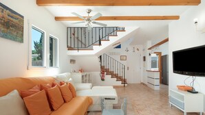 A modern living room with a sofa, glass coffee table, and a TV. - Villas 2meet La Yuca – Holiday Home with Private Pool in Cala Romántica, Mallorca (Romàntica)