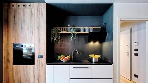 Eine moderne Küche mit Einbauofen, Spüle und einer Wand mit Holzvertäfelung.