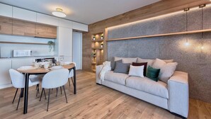 Ein stilvolles Wohnzimmer mit Essbereich, einer Couch und eingebauten Regalen.