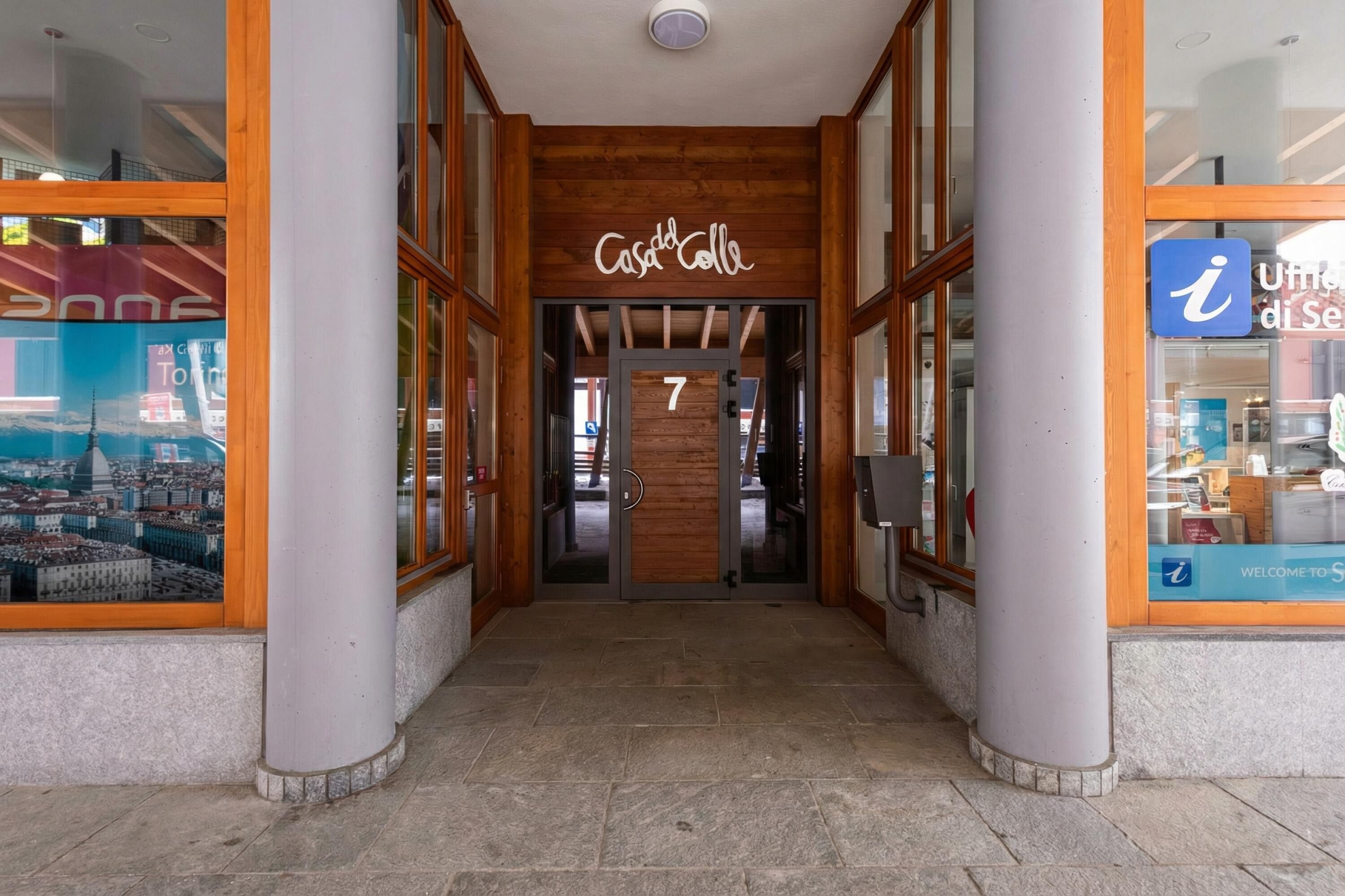 A hotel entrance with a wooden facade, a number 7 sign, and large windows.
