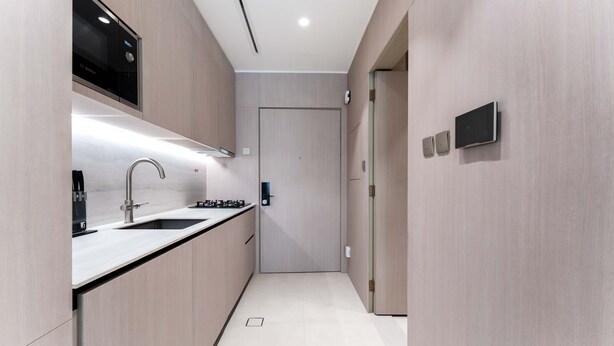 A modern kitchen with a built-in Bosch microwave, a stainless steel sink, and a sleek faucet. - Stayshort - Elegant Studio Living in JVC Perfect for 2 (Dubai)