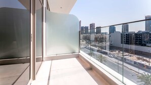 A balcony with a clear view of a cityscape, including high-rise buildings and a busy street. - Stayshort - Elegant Studio Living in JVC Perfect for 2 (Dubai)